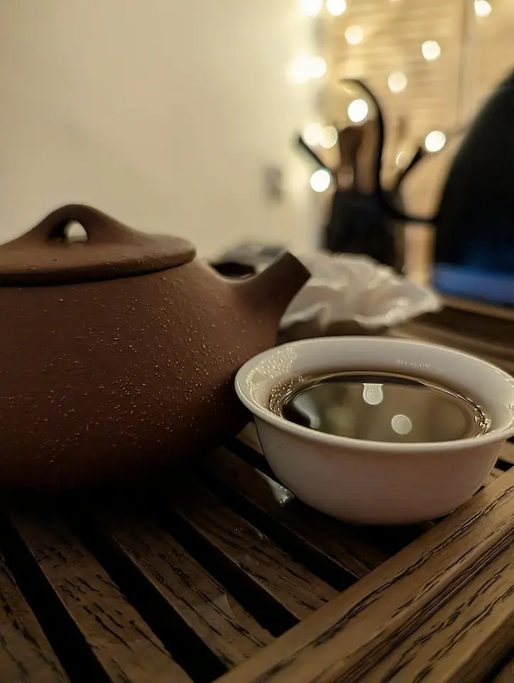 Пиала и чайник на фоне гирлянды